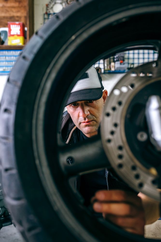 Mechanic fixing custom motorcycle wheel