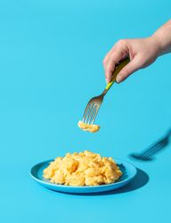Eating scrambled eggs, minimalist on a blue background