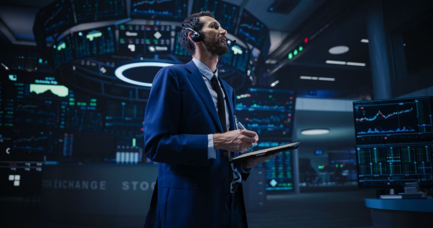 Productive Stock Exchange Broker Working on a Tablet Computer, Manipulating Company Shares, Valuable Technology Investments, Public and Private Securities.