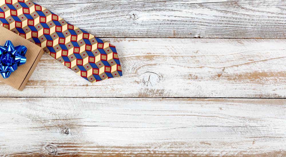 Happy Fathers Day concept with simple gift box and dress tie on rustic wood with plenty of copy space