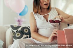 Pregnant woman opening presents after baby shower 4d8AQD