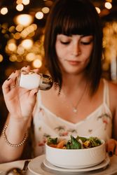 Woman salting salad in restaurant