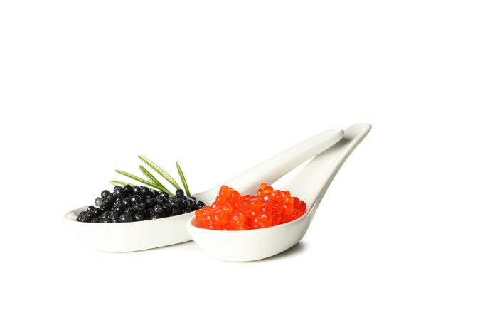 Glass spoons with caviar isolated on plain background