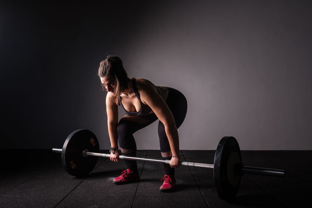 Woman lifting barbell in gym