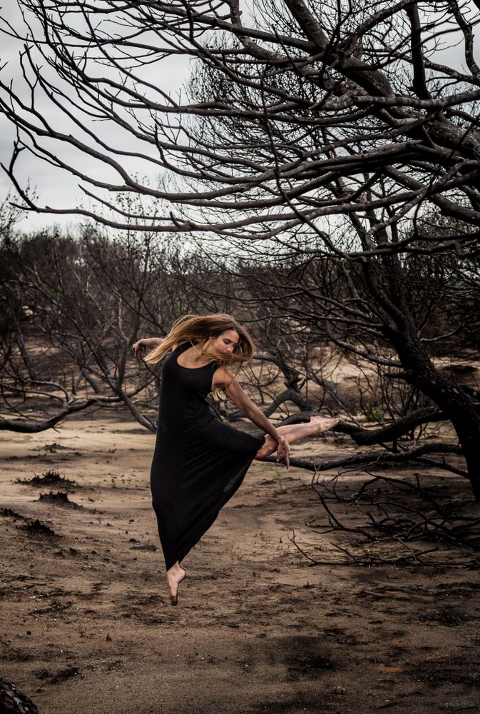 Woman dancing between dry trees