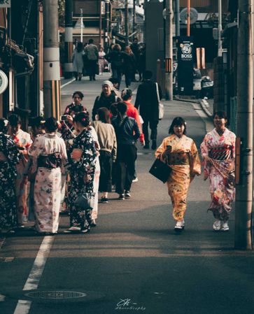 Groups of Japanese women in kimonos walking down the street in Osaka, Japan