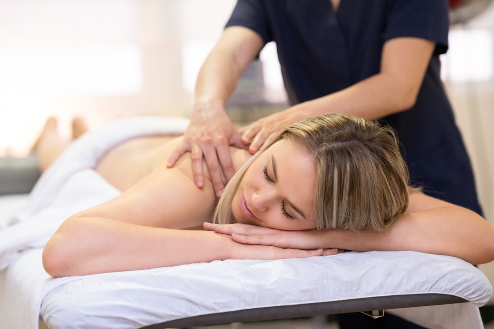 Blonde female being massaged on a table
