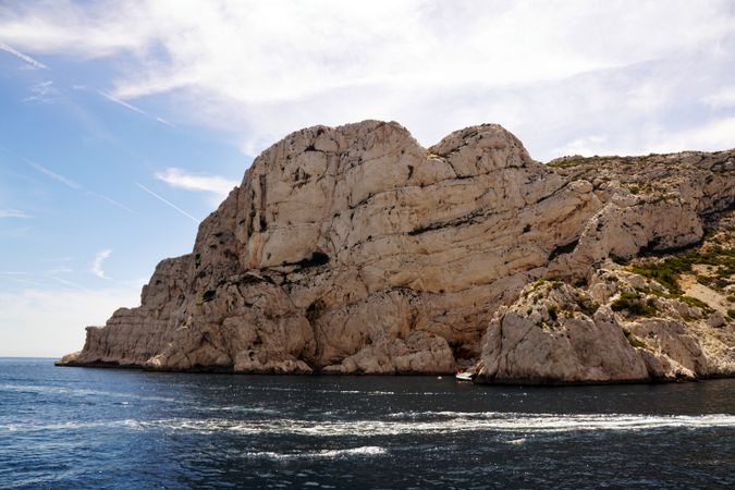 Limestone rocks and boat sailing in sea