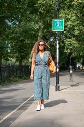 Black woman walking on city road, vertical