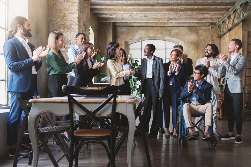 Multi-ethnic team celebrating success in modern office