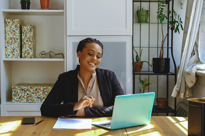 Business owner taking video call on her laptop in her home office