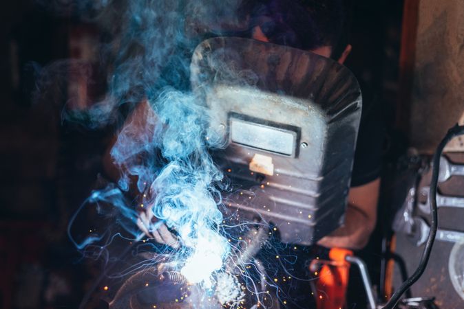Professional welder in mask welding metal