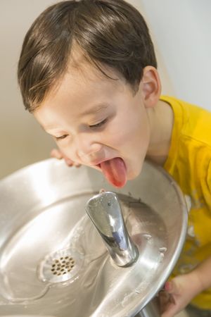 Biracial Boy Drinking From the Water Fountain