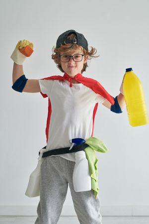 Happy boy holding plastic bottle standing in studio