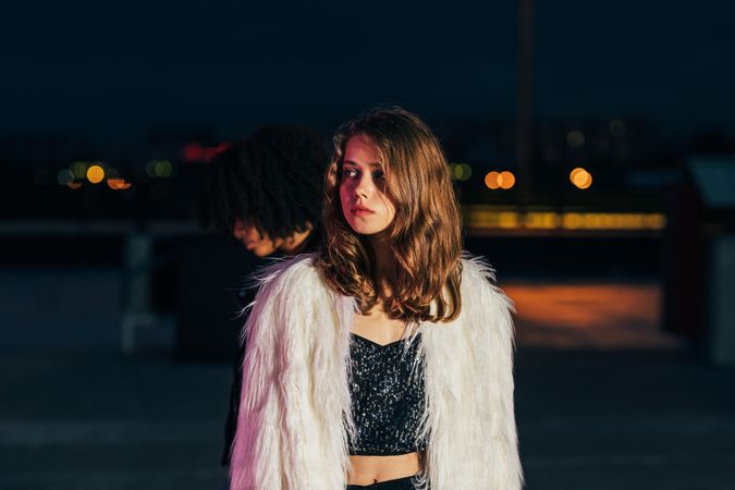 Serious looking woman in fluffy faux fur on rooftop