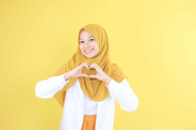 Young Asian Indonesian Woman with Casual Hijab Fashion Making Heart Shape with Her Hand