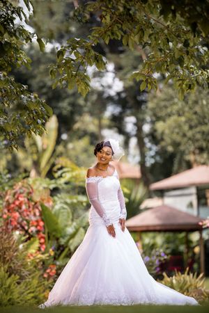 Smiling bride standing under a tree in a garden