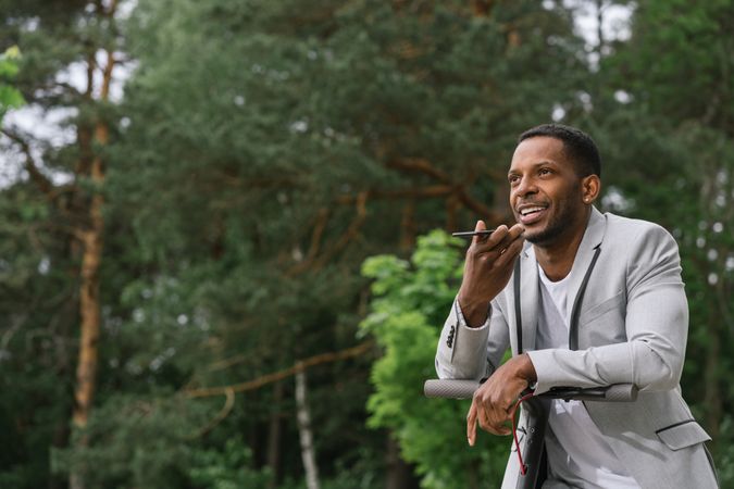 Black man on scooter talking on smartphone