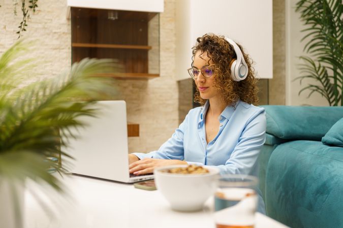Woman working from home in living room using headphones