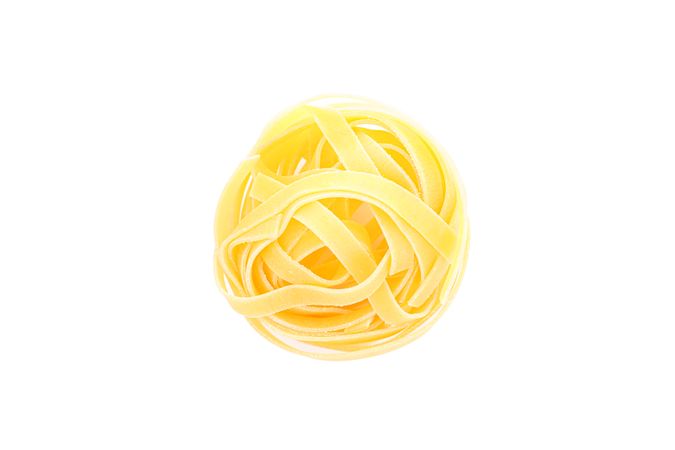 Pasta isolated on light background, top view. Traditional shape of dry uncooked whole pasta