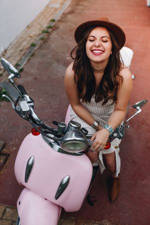 Woman smiling with face up sitting on motorbike
