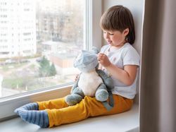 Toddler boy sits with koala bear in medical masks