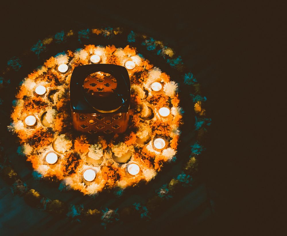 Assorted flowers and lit diyas in a circular shape