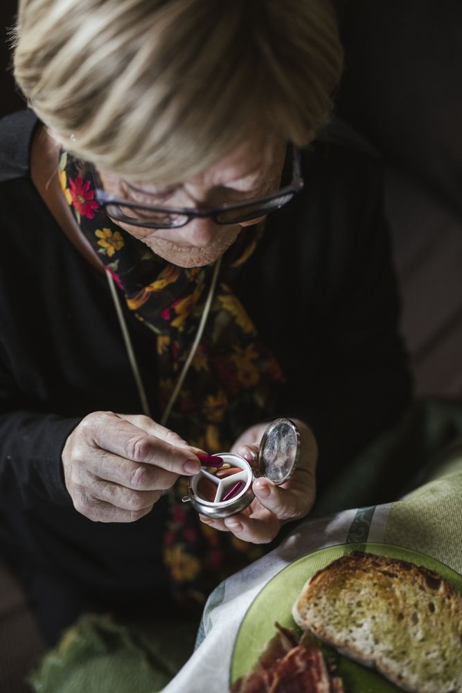 Hand of woman taking pill from box