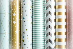 Rolls of festive wrapping paper as background. Top view