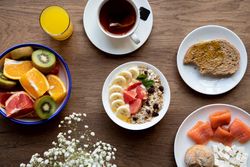 Juice and plate with granola and fruits on table