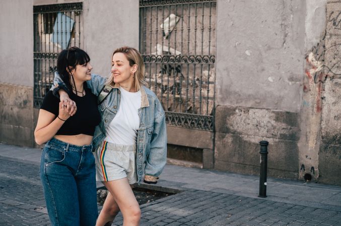 Lesbian couple hugging and walking on street