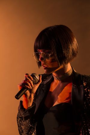 Stylish woman singing on stage
