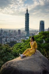 Young resting woman delighting in views in rock at big city