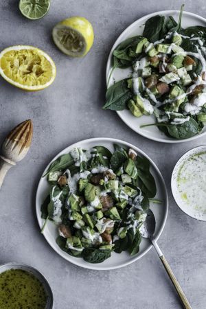 Tasty green salad with salmon on table decorated with citruses