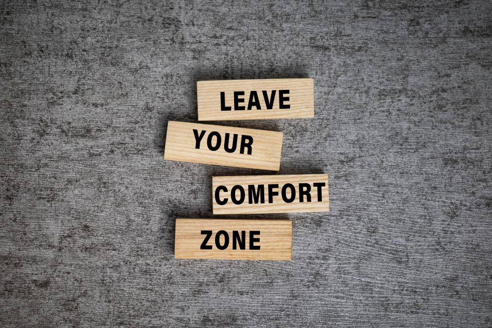 leave your comfort zone words on wooden blocks isolated on grey surface