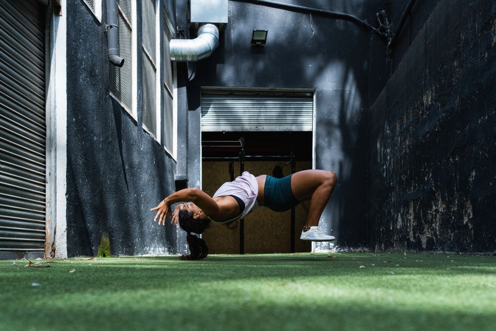 Fit woman doing somersault during training