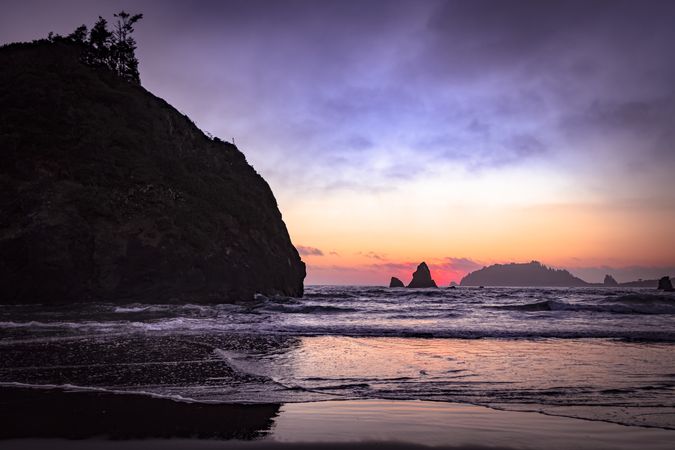 Looking out at rocks from the coast at dusk