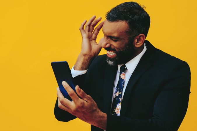 Frustrated Black businessman having a video call on a smartphone screen and grimacing
