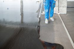 Crop masters pouring liquid concrete on floor at construction site