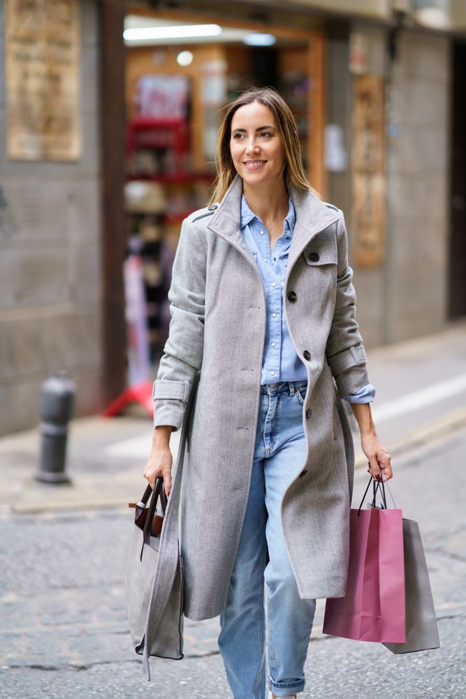 Chic woman walking with shopping bags outside
