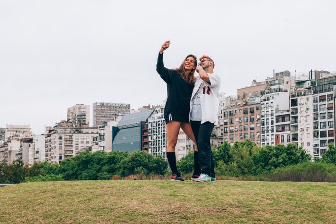 Friends smiling while making selfie on smartphone at city