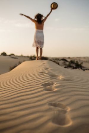 Active woman walking in dry desert barefoot