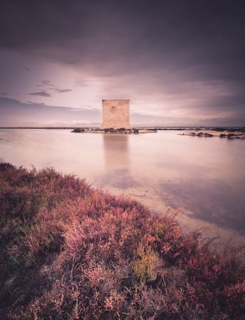 Wonderful watchtower in calm lake on cloudy day