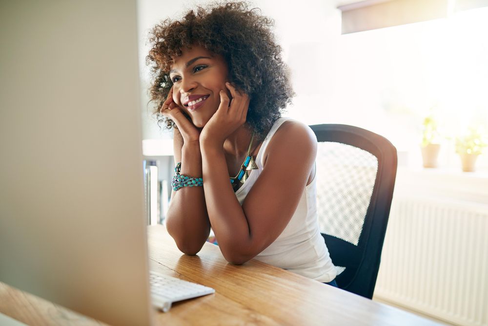Female at her home office desk reading computer screen