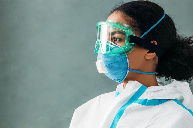 Proud Black female medical professional in PPE gear, side view