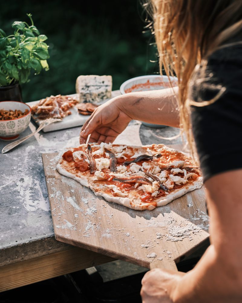 Back view of woman preparing pizza