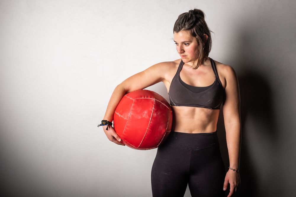 Woman lifting medicine ball in gym