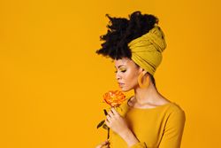 Portrait of Black woman holding a rose to her nose