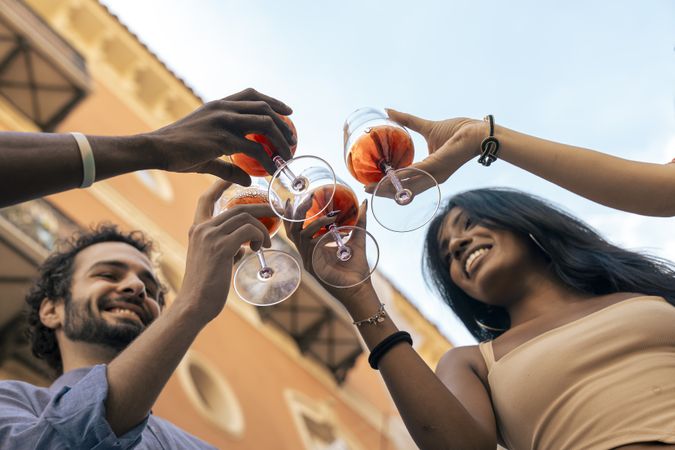 Low-angle view of friends toasting with rosé wine