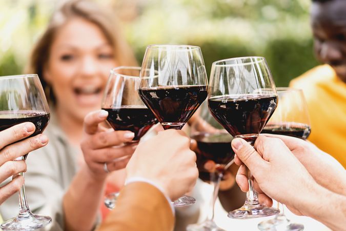 Cropped shot of friends toasting wineglasses of cabernet